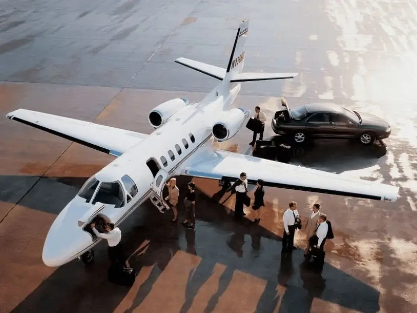 Business people boarding and around an airplane on a glittering tarmac. 